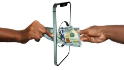 En la foto: Dos manos con dólares en la mano.